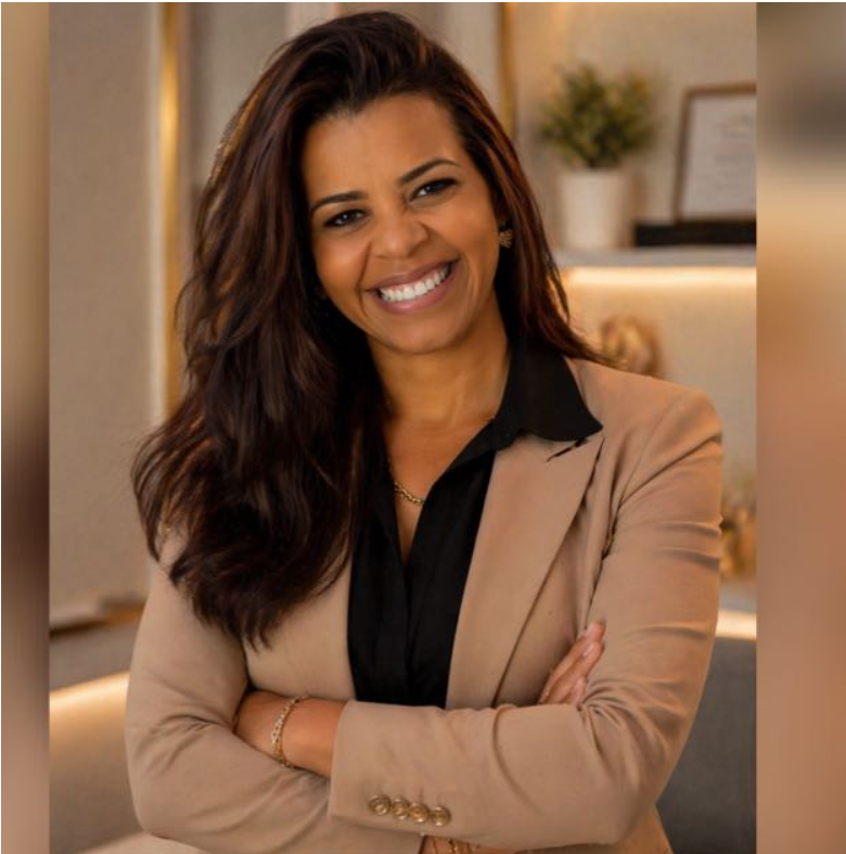 Retrato profissional de Aline Oliveira, de blazer, com os braços cruzados