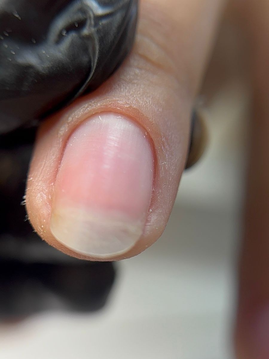 Unha natural em close, sem esmalte, com a cutícula recém trabalhada e a pele preservada
