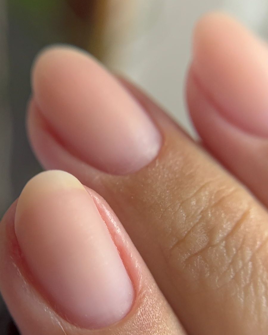 Unhas naturais em close, sem esmalte, com a região da cutícula limpa e a pele preservada